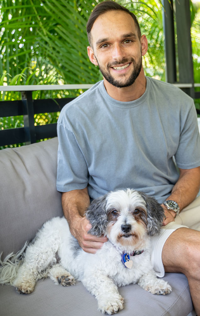 RSPCA Qld Ambassador, Jack Hingert, sits with her rescue dog, Chloe